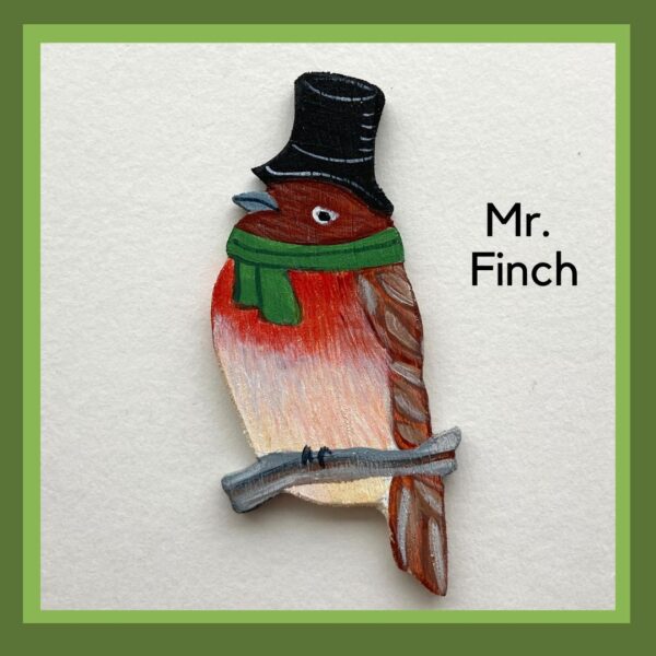 A red finch bird wearing a top hat and a green scarf. Mr. Finch is sitting on a branch.
