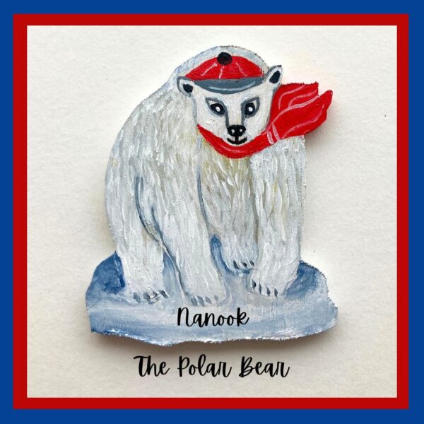 A wooden ornament of a white polar bear named Nanook. He is wearing a red cap and a red scarf. Nanook is standing on a patch of ice.