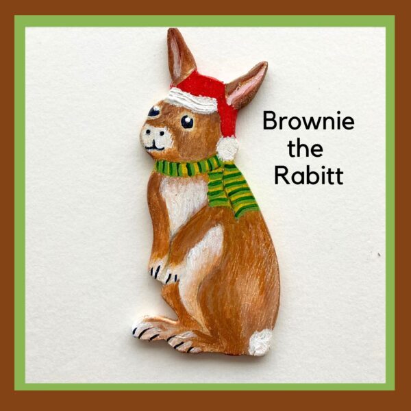 Brown Rabbit wooden ornament wearing a Santa hat and a green striped scarf.
